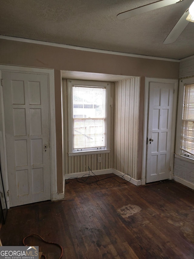 entryway with dark wood-type flooring, ceiling fan, and a textured ceiling