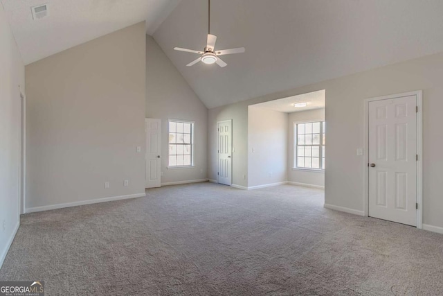 unfurnished room featuring ceiling fan, high vaulted ceiling, a wealth of natural light, and light colored carpet