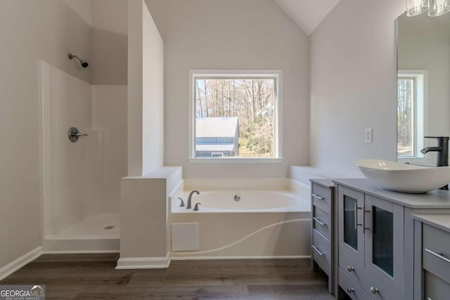 bathroom with lofted ceiling, vanity, hardwood / wood-style floors, and plus walk in shower