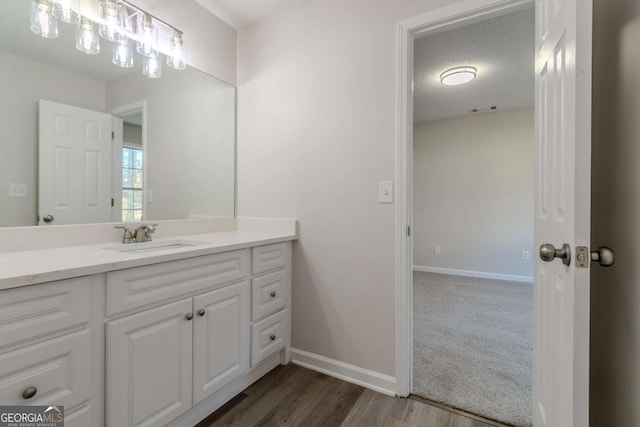 bathroom featuring vanity, a textured ceiling, and hardwood / wood-style floors