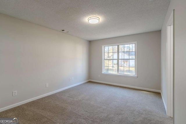 empty room with a textured ceiling and carpet floors