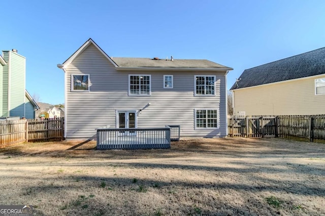 rear view of house with a yard and a wooden deck