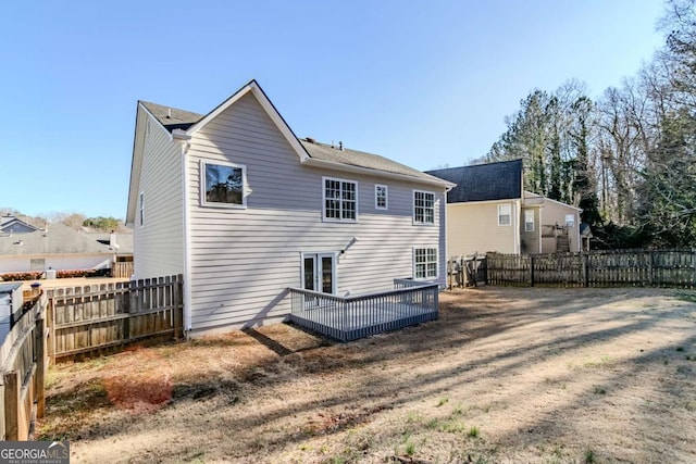 rear view of house featuring a deck and a yard