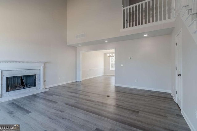 unfurnished living room featuring a high ceiling and hardwood / wood-style flooring