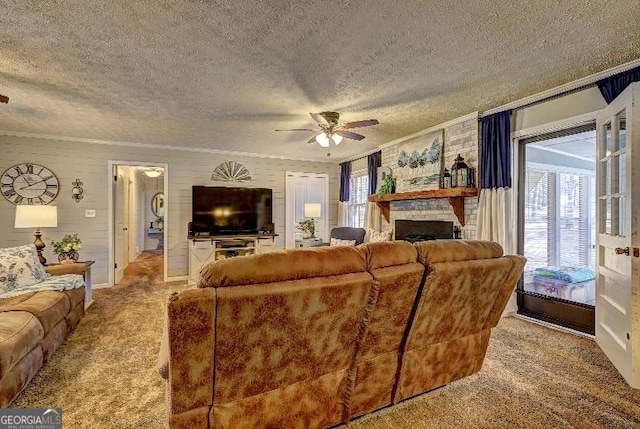 living room with a textured ceiling, a brick fireplace, light colored carpet, ornamental molding, and ceiling fan