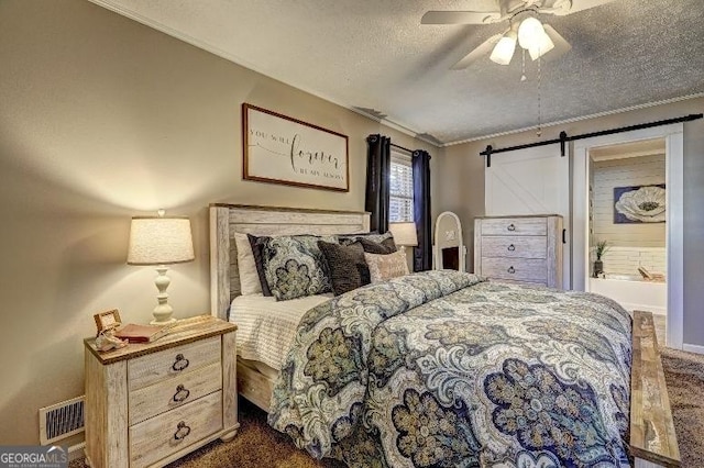 carpeted bedroom with a textured ceiling, ceiling fan, and a barn door