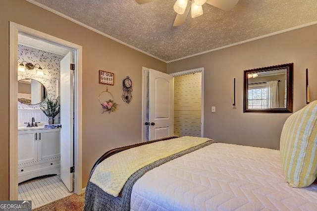 bedroom featuring ensuite bath, a textured ceiling, ceiling fan, and ornamental molding