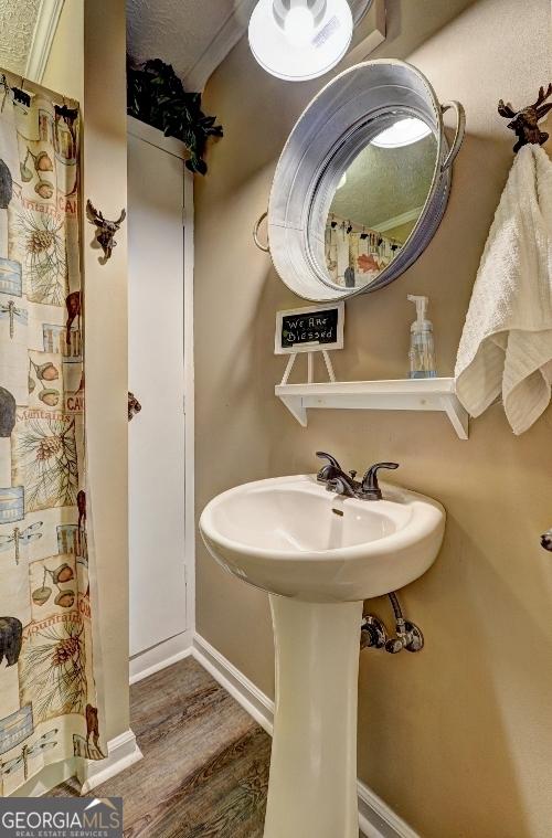 bathroom with crown molding and wood-type flooring