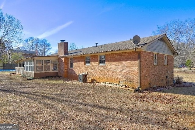 back of property featuring central AC and a sunroom