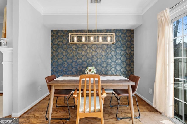 dining area featuring ornamental molding and light hardwood / wood-style floors