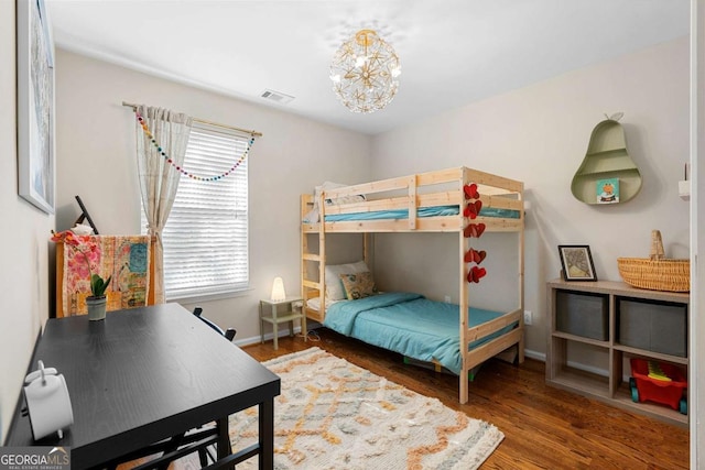 bedroom with an inviting chandelier and hardwood / wood-style floors