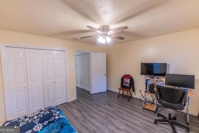 office featuring a textured ceiling, ceiling fan, and wood-type flooring