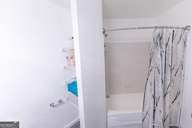 bathroom featuring shower / bathtub combination with curtain and a textured ceiling