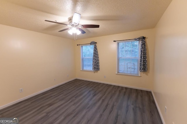 empty room featuring a textured ceiling, dark hardwood / wood-style flooring, and ceiling fan