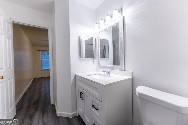 bathroom featuring toilet, wood-type flooring, and vanity