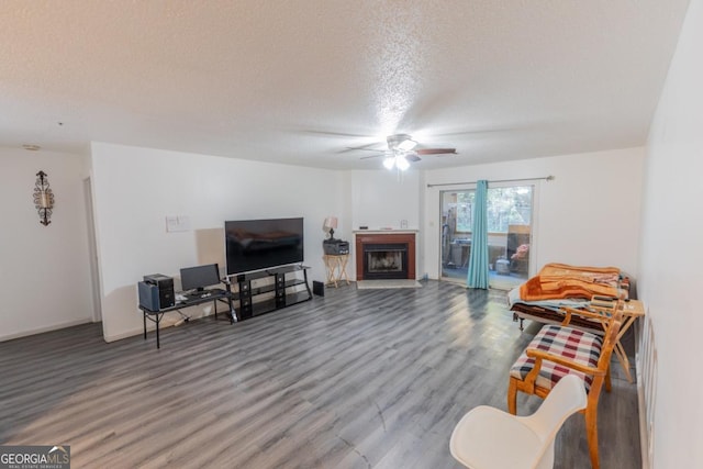 living room featuring a textured ceiling, hardwood / wood-style floors, and ceiling fan