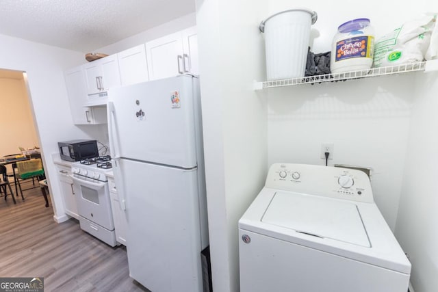 laundry room with a textured ceiling, light hardwood / wood-style floors, and washer / dryer