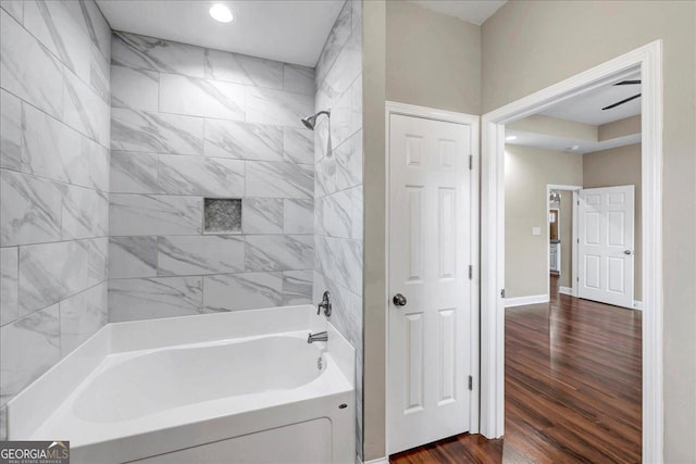 bathroom featuring wood-type flooring and tiled shower / bath