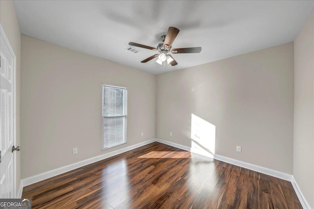 spare room with dark wood-type flooring and ceiling fan