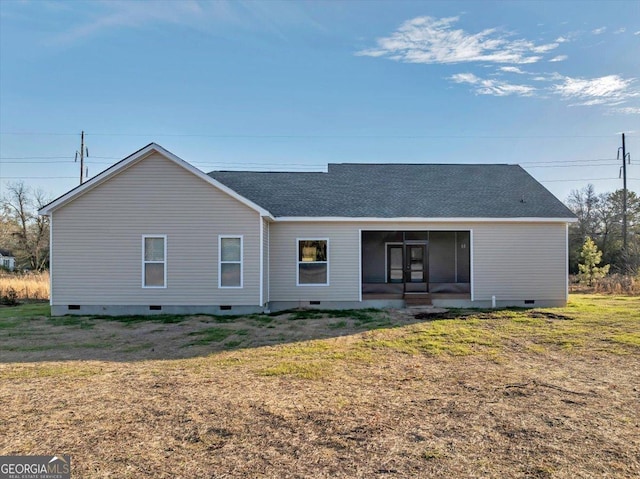 back of property with a lawn and a sunroom