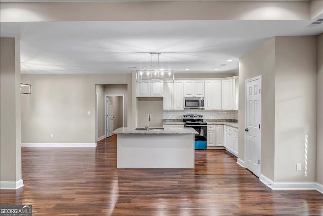 kitchen with sink, stainless steel appliances, white cabinetry, and a kitchen island with sink