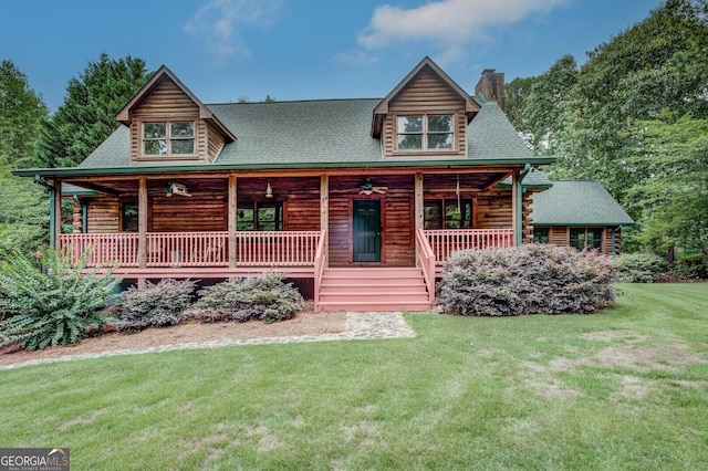 log home with a porch, ceiling fan, and a front lawn