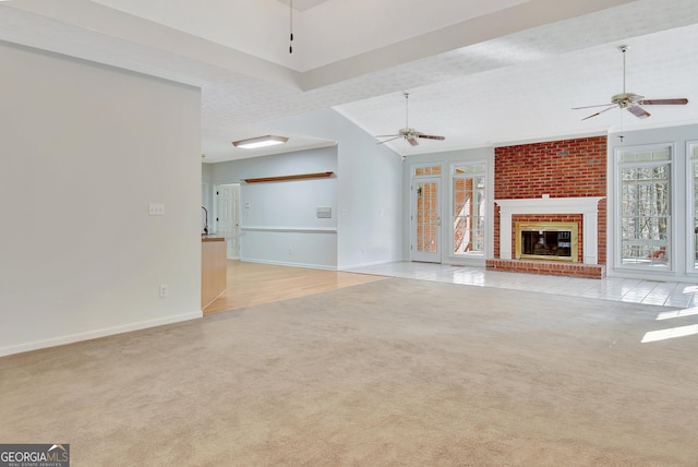 unfurnished living room with light colored carpet, a wealth of natural light, and a fireplace