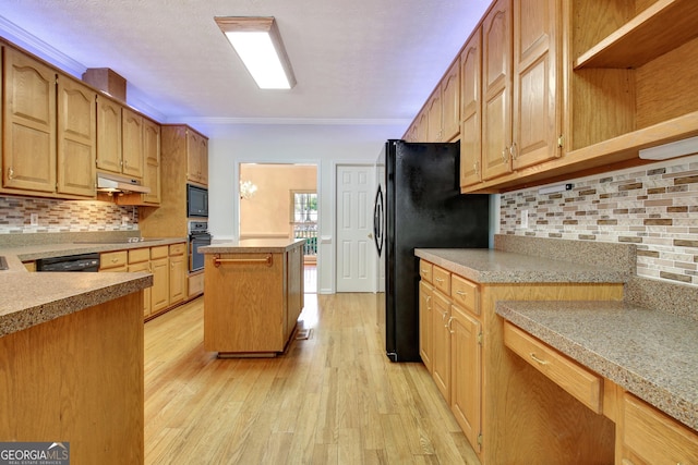 kitchen featuring light hardwood / wood-style floors, tasteful backsplash, a kitchen island, crown molding, and black appliances