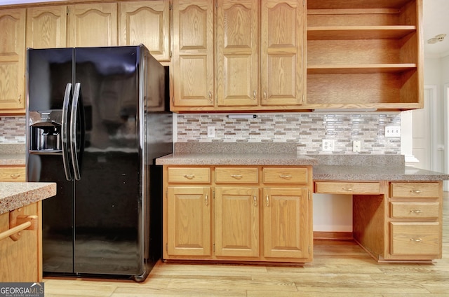 kitchen featuring black refrigerator with ice dispenser, light wood-type flooring, and tasteful backsplash