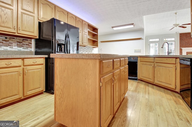 kitchen with sink, light hardwood / wood-style flooring, backsplash, and black appliances