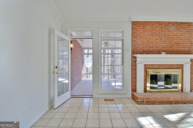 doorway to outside with light tile patterned floors, brick wall, a fireplace, and ornamental molding