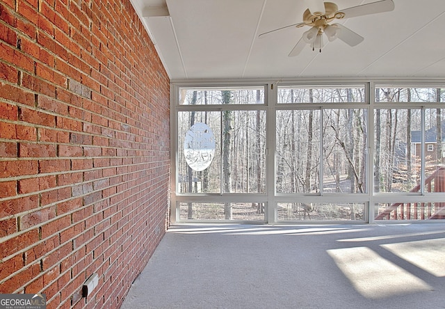 unfurnished sunroom with ceiling fan and plenty of natural light