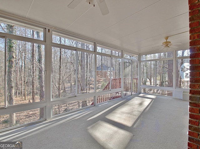 unfurnished sunroom featuring ceiling fan and plenty of natural light