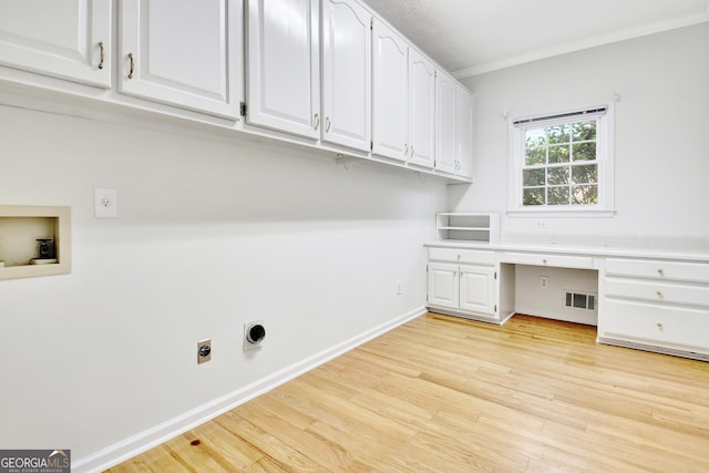 laundry room featuring light hardwood / wood-style floors, hookup for a washing machine, ornamental molding, electric dryer hookup, and cabinets