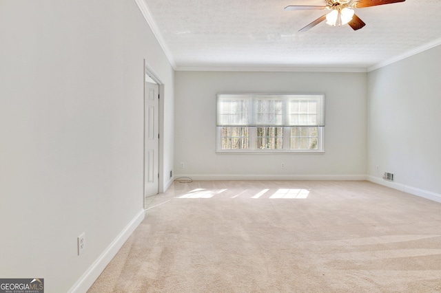 spare room with light carpet, ceiling fan, a textured ceiling, and ornamental molding