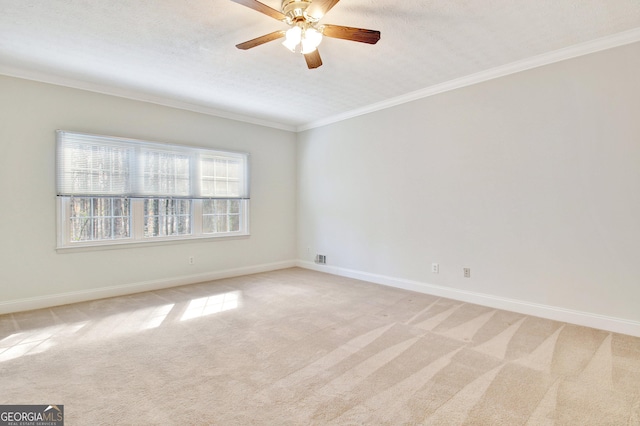 carpeted spare room with a textured ceiling, ceiling fan, and crown molding