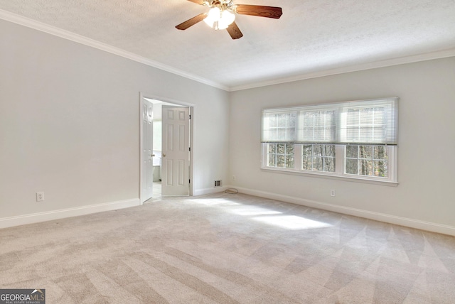 unfurnished room featuring ceiling fan, light colored carpet, a textured ceiling, and crown molding