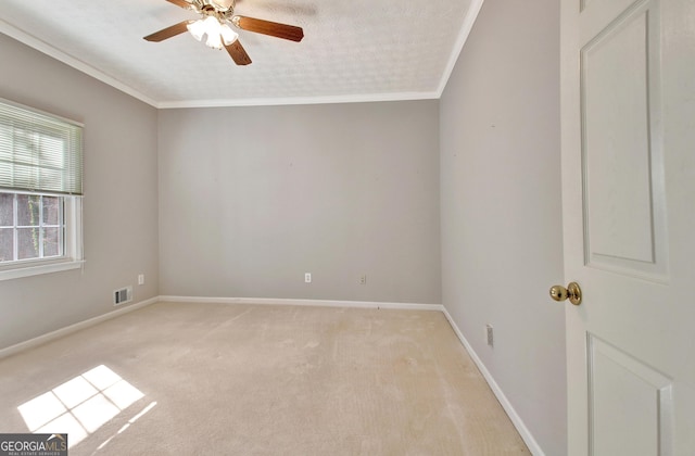 carpeted spare room with a textured ceiling, ceiling fan, and ornamental molding