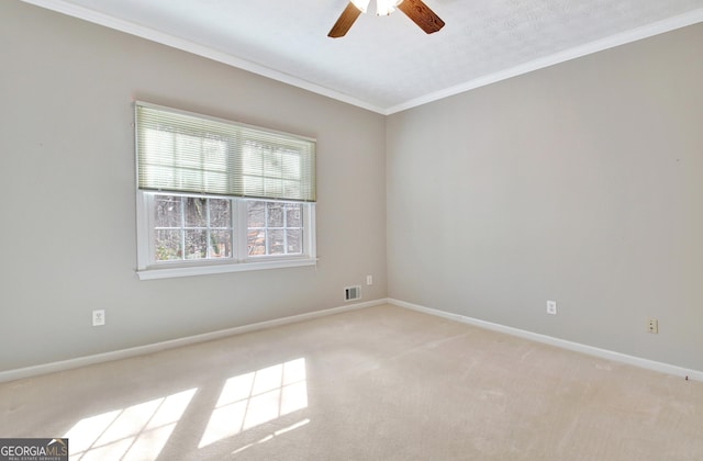 carpeted spare room with ceiling fan and ornamental molding