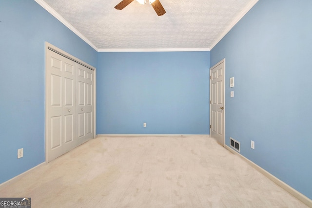 unfurnished bedroom with ceiling fan, light carpet, a closet, and ornamental molding