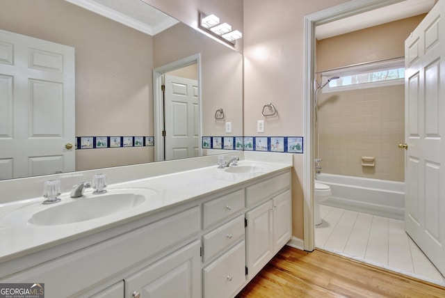 full bathroom with toilet, vanity, crown molding,  shower combination, and hardwood / wood-style flooring