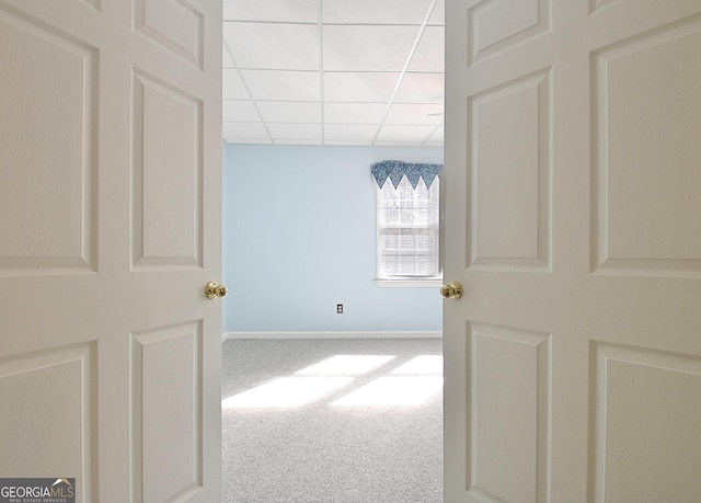 corridor with carpet and a drop ceiling