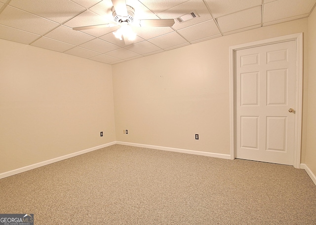 carpeted empty room with ceiling fan and a drop ceiling