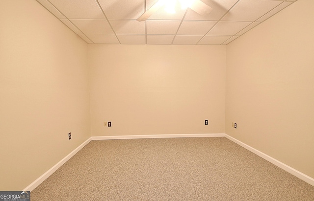 carpeted empty room featuring a drop ceiling