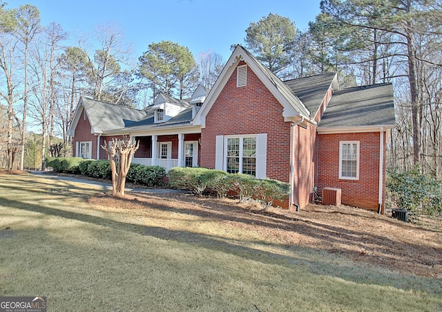 cape cod home with covered porch, a front yard, and central AC