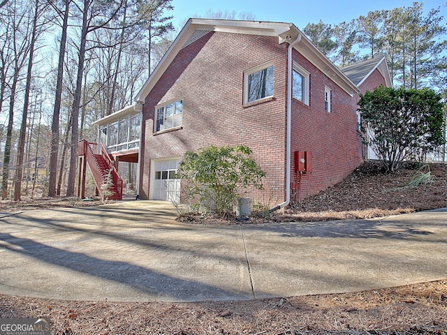 view of property exterior featuring a garage and a sunroom