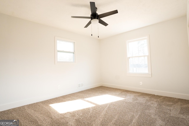 unfurnished room with ceiling fan, a wealth of natural light, and carpet flooring