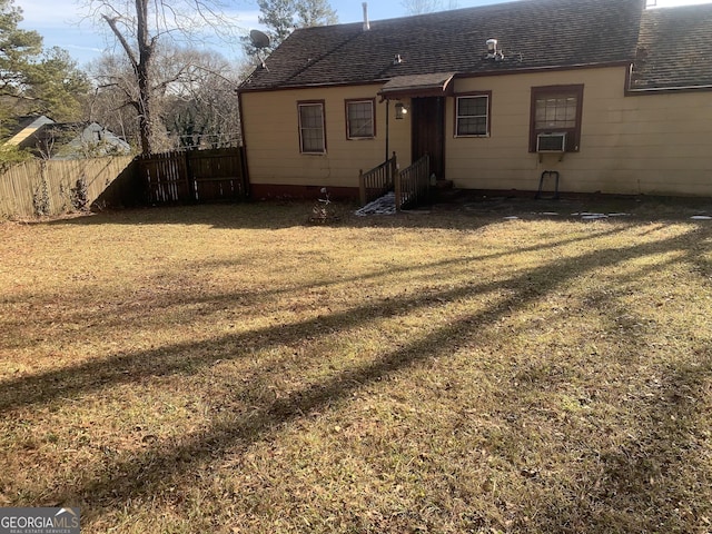 back of property with a lawn and cooling unit