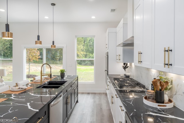 kitchen featuring decorative light fixtures, white cabinets, appliances with stainless steel finishes, and sink