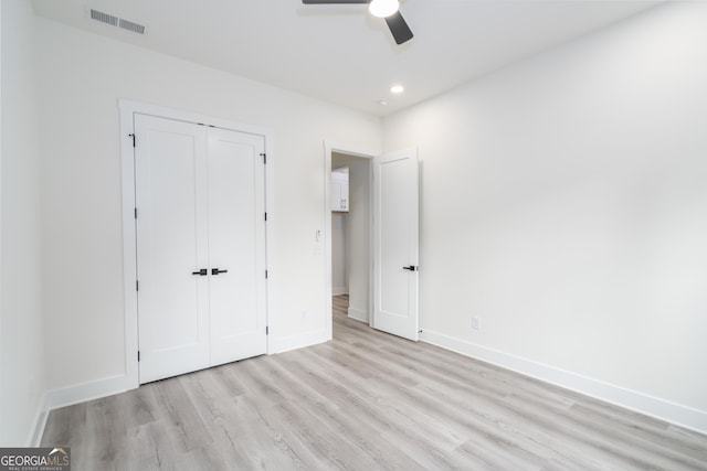 unfurnished bedroom featuring ceiling fan, light hardwood / wood-style floors, and a closet